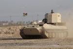 A metalworker rides a tank as he check the engine in Basra